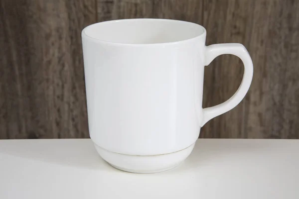 Taza blanca vacía en una mesa de madera . — Foto de Stock