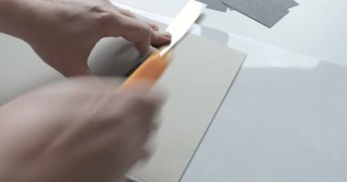 Erkek elin zaman atlamalı bir kalem ve kağıt levha üzerinde metal bir cetvel ile bir çizim yapar