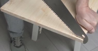 Tahta testereyle kesen bir adam.