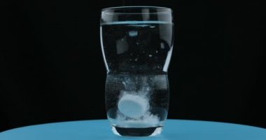 Aspirin ya da coşkun bir hap bir bardak suya düşüyor.