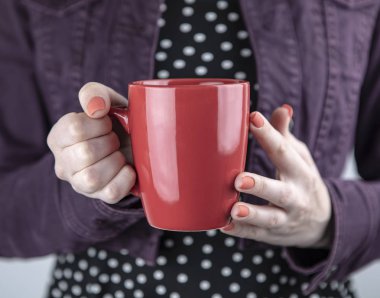 Elinde kırmızı kupa tutan bir kadın.