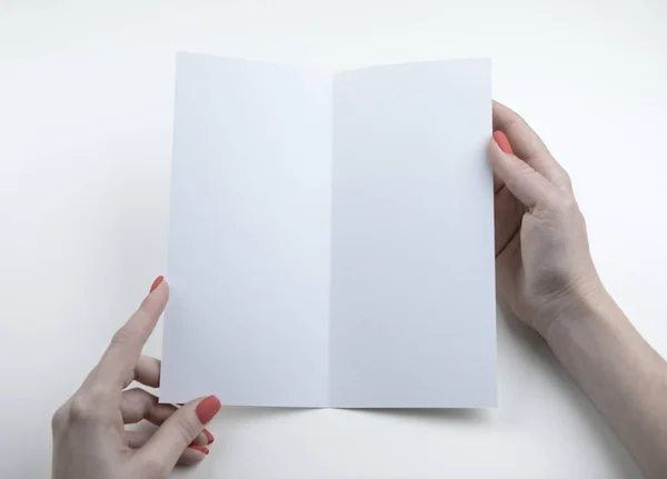 Een vrouw die een wit boekje vasthoudt — Stockfoto