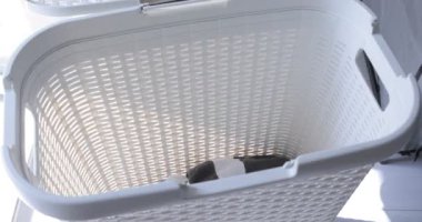 Kirli bez bir çamaşır sepeti düşüyor