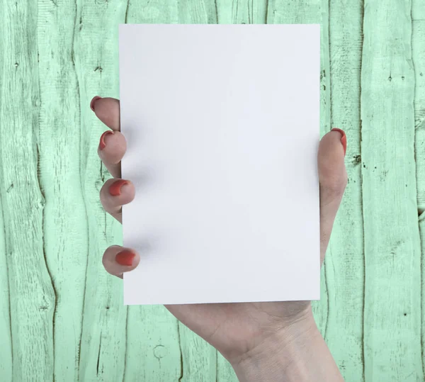 Beyaz kitapçık tutan bir kadın