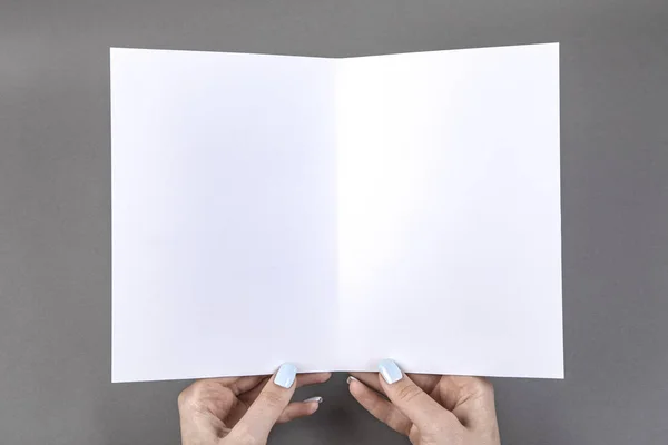 Una donna che tiene un libretto bianco — Foto Stock