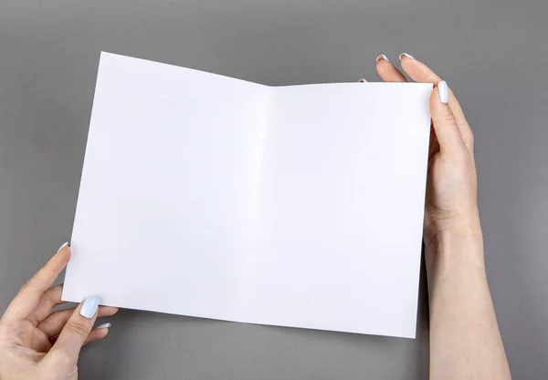 Una donna che tiene un libretto bianco — Foto Stock