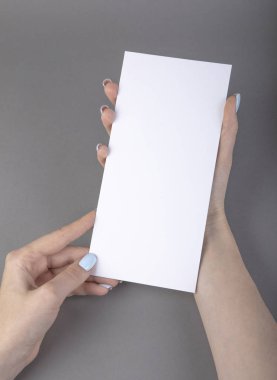 Beyaz kitapçık tutan bir kadın