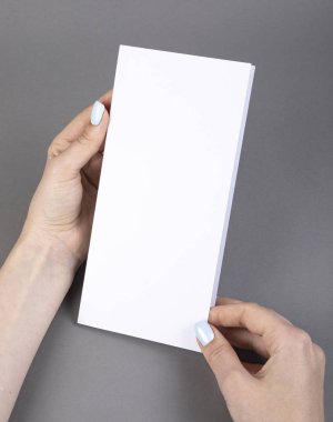 Beyaz kitapçık tutan bir kadın