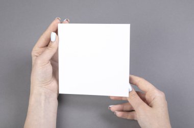 Beyaz kitapçık tutan bir kadın