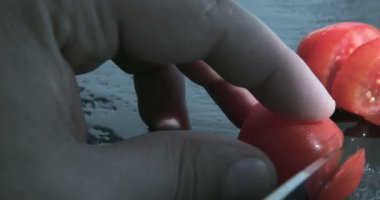 Şef siyah bir masada domates doğranmış