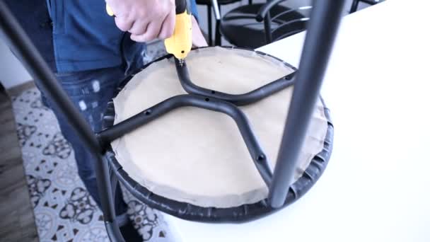 의자를 조립하는 스크루 드라이버를 가지고 일하는 — 비디오