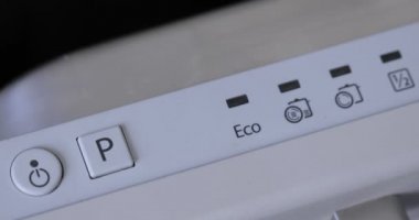 Bulaşık makinesindeki parmak kapatma düğmesine basar