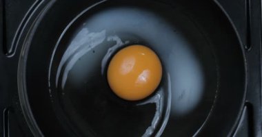 Domuz demiriyle kızartılmış yumurta pişirme işlemi. 