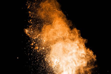 Turuncu ve kahverengi toz siyah arka plan üzerinde patlama.