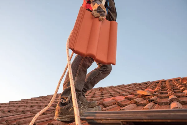 Arbeiter trägt Dachziegel auf dem Dach — Stockfoto