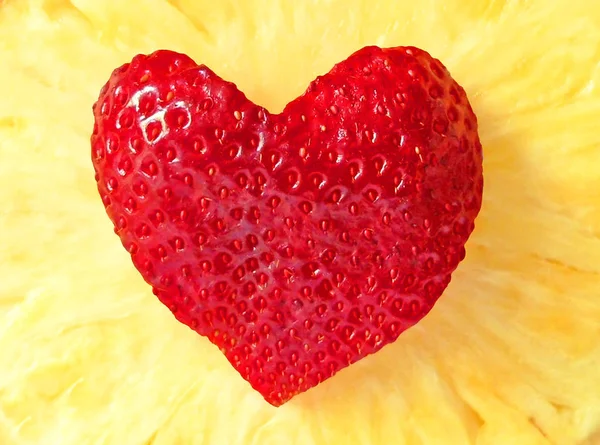 Strawberry heart on pineapple background — Stock Photo, Image