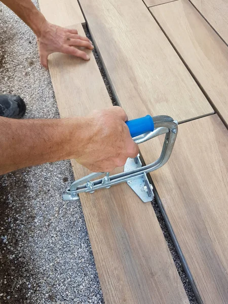 Paving a patio - fitting the stone tile with a slab heaver — Stock Photo, Image