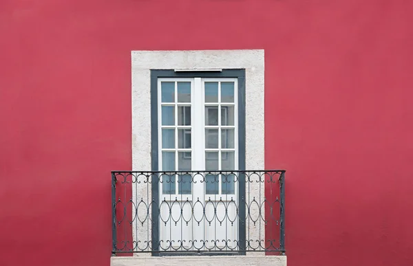 Facciata della casa rossa con piccolo balcone e porta, incorniciata bianca — Foto Stock