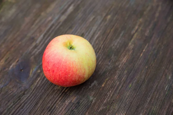 Una manzana sobre una mesa de madera rústica —  Fotos de Stock
