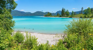 Walchensee Gölü kıyısında karibik hisler, turkuaz banyo ve dağ manzarası, popüler sörf merkezi Bavyera