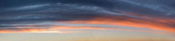 夕方の青空の上にグレーとオレンジの雲が広がるワイドスカイパノラマ — ストック写真