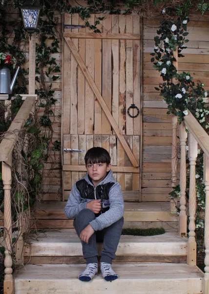 Kleiner Attraktiver Junge Sitzt Auf Holzstufen — Stockfoto