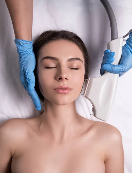 Injection beauté. Gros plan des mains du médecin avec seringue près du visage féminin. Portrait d'une belle femme recevant un traitement de levage de peau faciale . — Photo