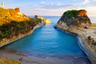 Güzel kayalık sahil şeridi gündoğumu Sidari tatil köyü Corfu Adası Yunanistan'ın, şaşırtıcı mavi İyon Denizi ile ünlü Canal d'Amour plaj