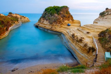 Güzel kayalık sahil şeridi muhteşem mavi Ionian Sea Sidari tatil köyü Yunanistan, Europe Corfu adasında sunrise adlı ile ünlü Canal d'Amour plaj