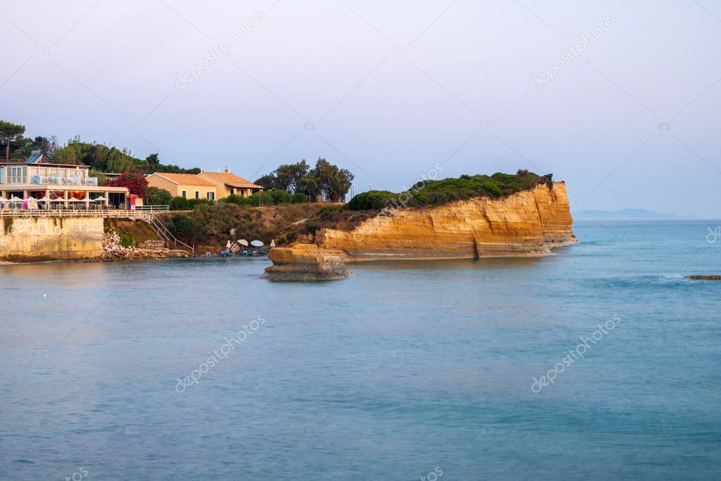 Famous Canal d'Amour beach with beautiful rocky coastline in amazing blue Ionian Sea at sunrise in Sidari holiday village on Corfu island in Greece