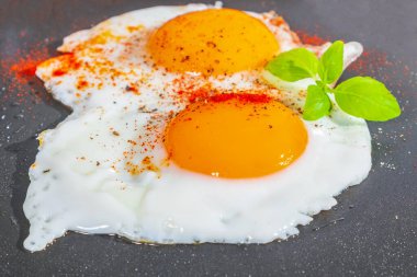 Kızartma tavasında iki taze yumurta, güzel yumurta sarısı, arka planda ağız sulandıran yemek.
