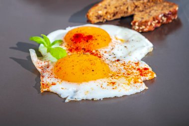 Kızartma tavasında iki taze yumurta, güzel yumurta sarısı, arka planda ağız sulandıran yemek.