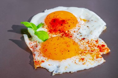 Kızartma tavasında iki taze yumurta, güzel yumurta sarısı, arka planda ağız sulandıran yemek.