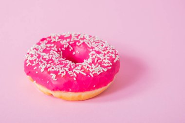 Renkli lezzetli çörekler, pembe arka planda şeker jöleli.