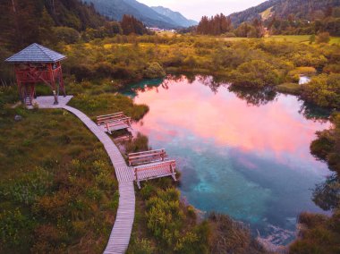 Slovenya 'da gün batımında Kranjska Gora yakınlarındaki Triglav Ulusal Parkı' ndaki Julia Alpleri 'ndeki güzel Zelenci gölünün hava manzarası