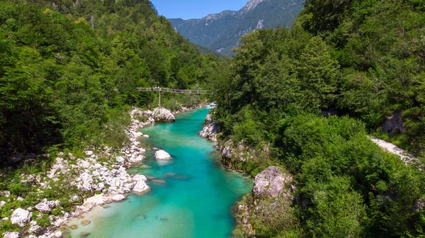 Aerial view of the turquoise blue Soca river (Isonzo) and wooden bridge near Bovec in the Julian Alps in Slovenia