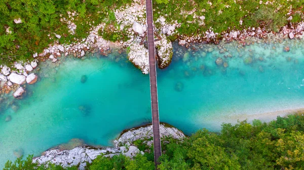 Slovenya 'daki Julian Alpleri' nde Bovec yakınlarındaki turkuaz mavi Soca nehri (Isonzo) ve ahşap köprü havadan görülüyor.