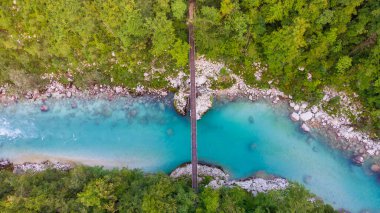 Slovenya 'daki Julian Alpleri' nde Bovec yakınlarındaki turkuaz mavi Soca nehri (Isonzo) ve ahşap köprü havadan görülüyor.