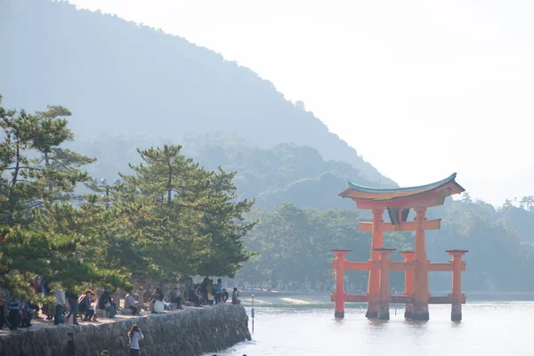 游客在广岛宫岛看到神社的浮都门，看到银杏叶 — 图库照片