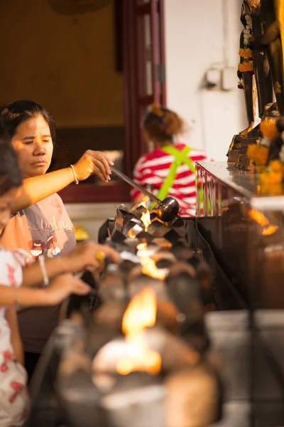 People fill oil on lantern in Wat Rakhang Khositaram — Stock Photo, Image