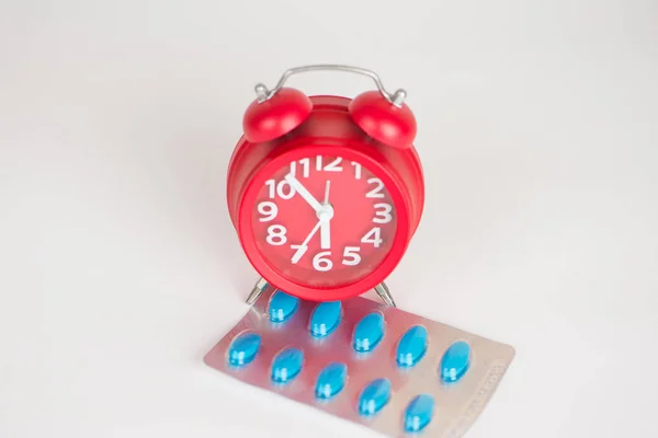 Jam merah dan pak blister menunjukkan konsep obat — Stok Foto