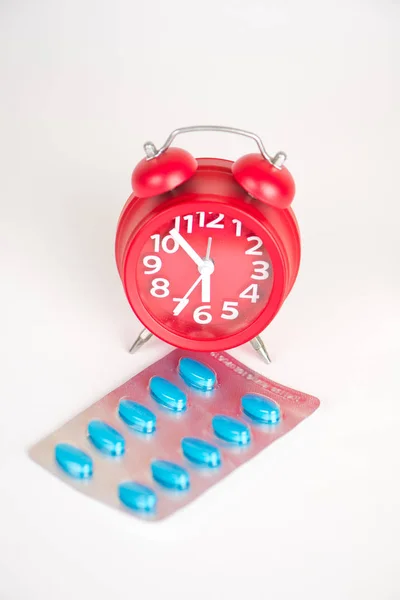 Red clock and blister pack show medicine concept — Stock Photo, Image