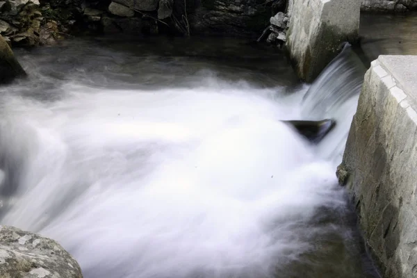 Agua que fluye en una pequeña cascada — Foto de Stock