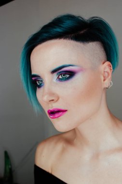 Renkli dumanlı gözlü, mavi saçlı ve stüdyoda mükemmel ciltli güzel seksi bir kızın portresi. Yüzük ışığı. Güzellik blogu. Gözlerini aç..