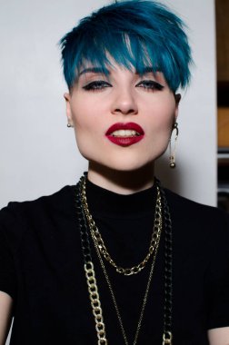 İzole gri duvar arka plan üzerinde bir kadın whith parlak mavi saç moda vurdu. Profesyonel model Dergi kapağı için poz