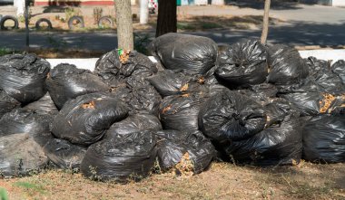 siyah çöp poşetleriyle atık yalan doğrudan üstünde belgili tanımlık yol. Büyük şehirde, kirliliği çöp yan yol, patika üzerinde siyah çöp yığını