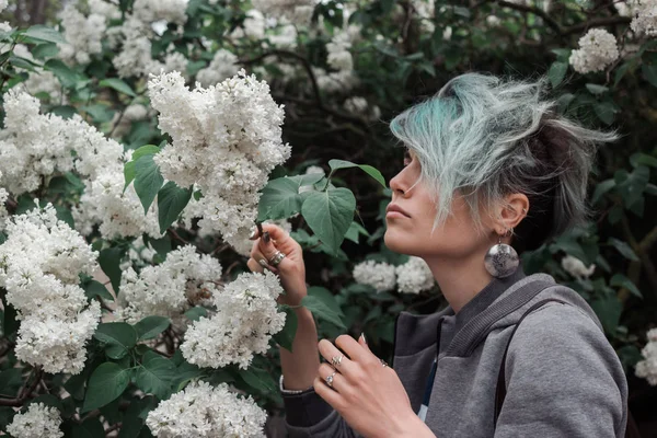 春には青い髪の女の子が庭で花を咲かせます — ストック写真