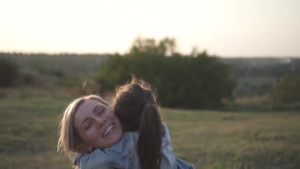 快乐的母亲快乐的母亲微笑着拥抱女儿 混血家庭 欧洲母亲和亚洲女儿在日落时在公园里度过的时光 温暖的春天或夏季 — 图库视频影像