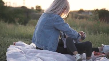 Karışık yarış Aile, Avrupa anne ve Asyalı kızı vakit parkta sunset Bulvarında. Onlar zemin gıdıklama birbirimize yalan ve gülümseyen oynamak. Bahar ya da yaz sezonu sıcak.