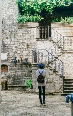 Kız bir demir merdiven ve yeşillik zemin karşı eski Avrupa şehri yürür.